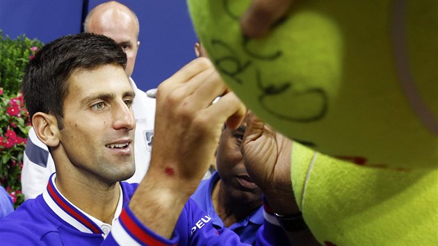 PODPISY FANOUKM. Novak Djokovi se po triumfu na US Open podepisuje fanoukm.