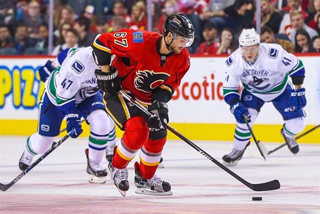 Michael Frolík z Calgary ujídí obran Vancouveru.