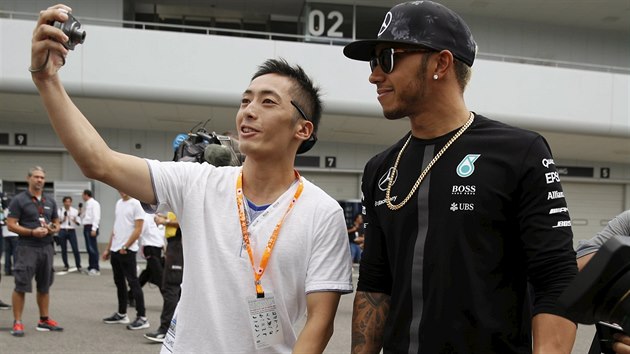 Japonsk fanouek si poizuje selfie s Lewisem Hamiltonem.