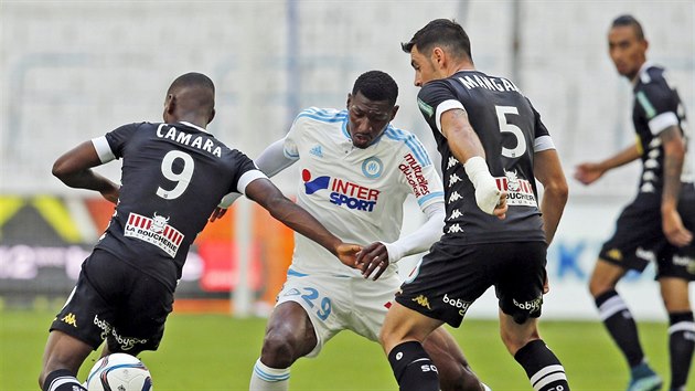 Zambo z Marseille mezi hri Angers Camarou (vlevo) a Manganim.