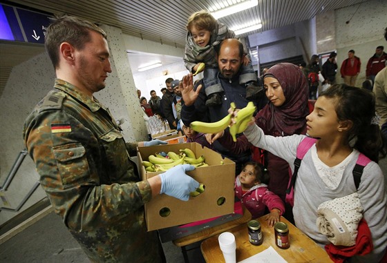 Nmecký voják rozdává na berlínském vlakovém nádraí jídlo uprchlíkm, kteí...