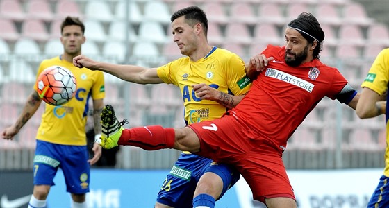 Roman Potoný z Teplic (vlevo) a útoník Brna Pavel Zavadil v souboji o balón