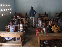 Teacher Kahon Rochel poses for a picture with students inside their classroom...