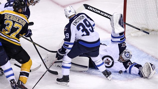 Ondej Pavelec z Winnipegu zasahuje v zpase s Bostonem.