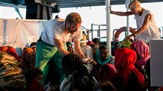 Will Turner a Mary Jo Frawleyová  rozdávají jídlo uprchlíkm na lodi Léka bez...