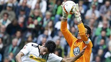Gólman Wolfsburgu Diego Benaglio (vpravo) zasahuje ped dotírajícím Larsem...