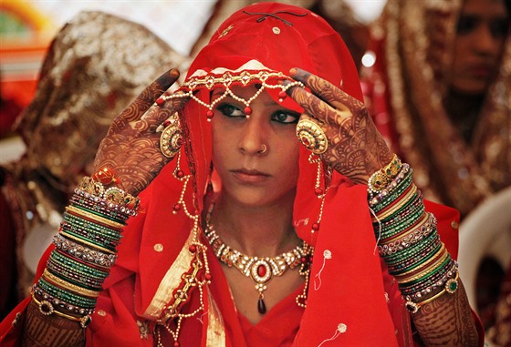Indická nevsta si upravuje átek pi slavnosti, bhem ní bylo v Ahmadábádu sezdáno edesát pt pár.