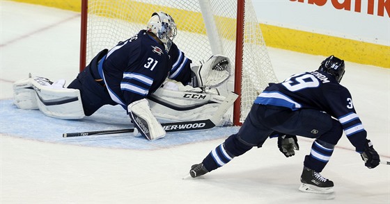 Ondej Pavelec (31) z Winnipegu zasahuje v utkání se St. Louis, sleduje ho...