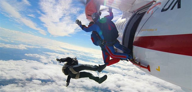 Roman tengl (v modrém) pi výskoku z letadla pi tandemovém seskoku. Pod ním...