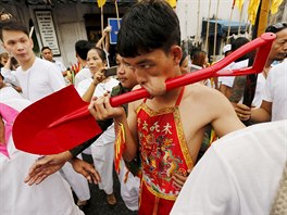 A devotee of the Chinese Bang Neow shrine with a shovel pierced through his...