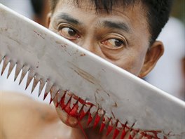 A devotee of the Chinese Bang Neow shrine cuts his tongue to make it bleed...