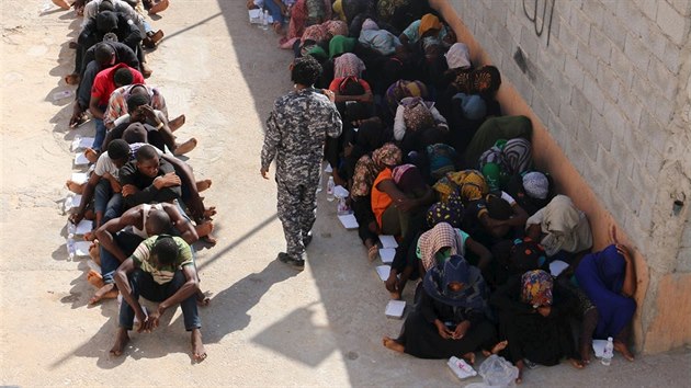 Migranti sed v libyjskm detennm centru. Tito lid byli zadreni libyjskmi ady v Tripolisu na cest do Evropy (12. jna 2015).