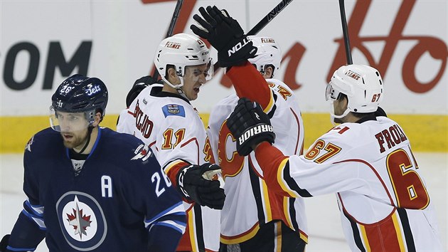 Michael Frolk (vpravo) se pipojuje k oslavm glu hokejist Calgary v utkn proti Winnipegu.