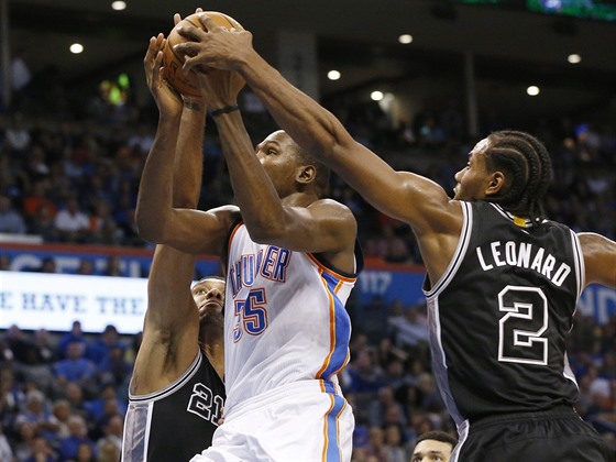 Kevin Durant z Oklahoma City se pokouí prosadit mezi dvojicí ze San Antonia -...