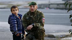 Slovintí policisté hovoí s malým uprchlíkem u hranic s Rakouskem (25. íjna...