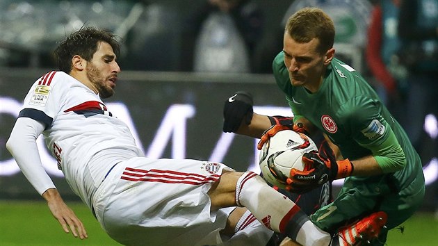Luk Hrdeck, brank Frankfurtu, zasahuje ped Javim Martinezem z Bayernu Mnichov.