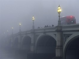 LONDÝNSKÉ MLHY. Lidé cestují do práce pes westminsterský most v Londýn....