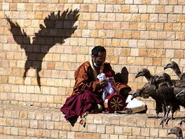 MRCHOROUTI. Buddhistický mnich sbírá své vci, zatímco se supi slétají kolem...