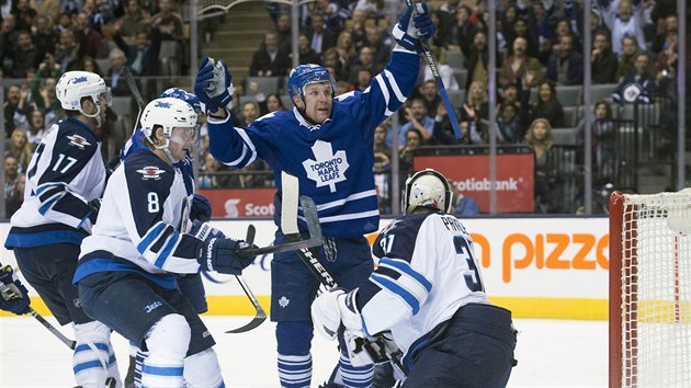 Leo Komarov z Toronta zved ruce na oslavu glu. Byl rychlej ne hri Winnipegu Adam Lowry (vlevo) a Jacob Trouba, zashnout nestail ani brank Ondej PAvelec.