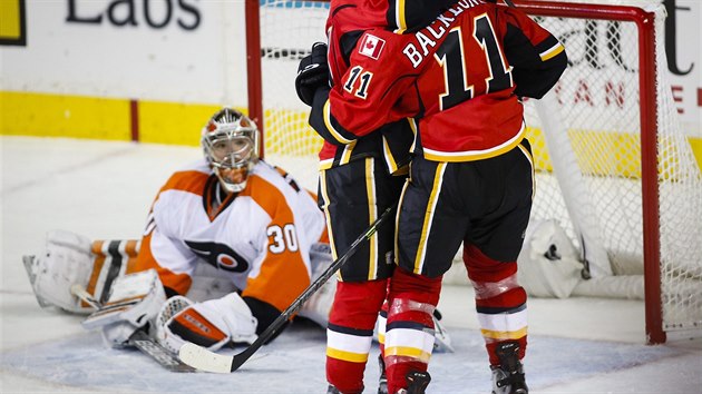 Brank Philadelphie Michal Neuvirth sleduje glov oslavy hokejist Calgary.