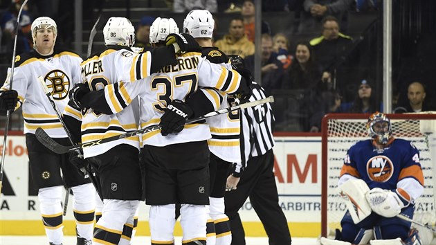 Hokejist Bostonu se raduj pot, co pekonali glmana Jaroslava Halka z New York Islanders.