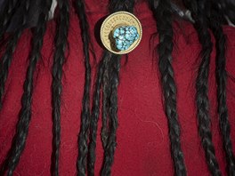 Ethnic Tibetan woman, wearing a traditional decoration in her hair prays at a...