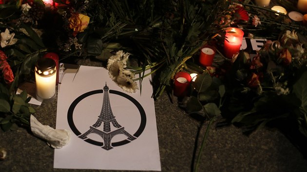 Plakt se symbolem Eiffelovy ve poloili lid mezi svky a kvtiny ped francouzskou ambasdu v Berln (14. listopadu 2015).