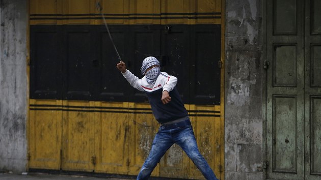 Palestinsk mladk vrh kameny na izraelsk jednotky bhem demonstrace v Hebronu na Zpadnm behu za vrcen tl palestinskch tonk, kte napadli noem nkolik Izraelc a pi svch tocch zemeli. (10. listopadu 2015)