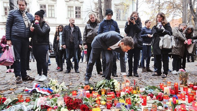 Ministr spravedlnosti Robert Pelikn zapaluje svku ped francouzskou ambasdou na Mal Stran (14.11.2015).