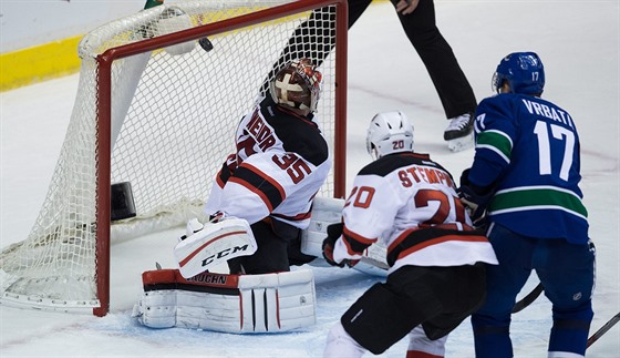 Radim Vrbata z Vancouveru pekonává brankáe New Jersey Coryho Schneidera.