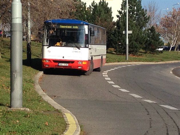 Autobus parkující v odboovacím pruhu v Horních Mcholupech.