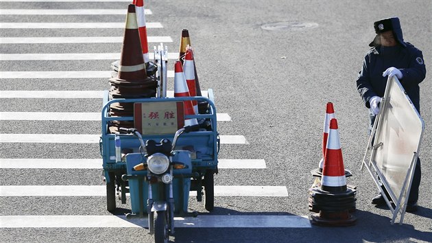 Pracovnk bezpenostn sluby odklz znaen usmrujc dopravu v okol pekingsk soudn sn, kde byl vyhlen vsledek odvolacho zen s novinkou Kao J. (26. listopadu 2015)