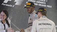 Mistr svta Lewis Hamilton zkrápí ampaským za dohledu týmového kolegy Nica...