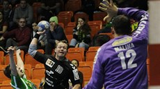 Lovosický Jiří Bouček (v černém) pálí na brankáře Zubří Milana Malinu. Lovosický Jiří Bouček (v černém) pálí na brankáře Zubří Milana Malinu.