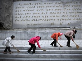 DESKA ZAKLADATELE. Severokorejské studentky zametají dlabu ped kamenným...
