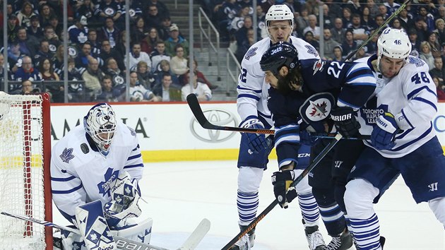 Roman Polk (vpravo) z Toronta se sna zablokovat winnipeskho Chrise Thorburna, zasahuje glman Garret Sparks, pihl Martin Marinin.