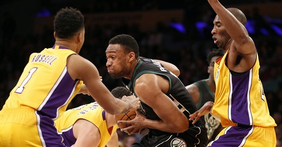 Jabari Parker (v tmavém) z Milwaukee proniká mezi obránci LA Lakers. Vlevo...