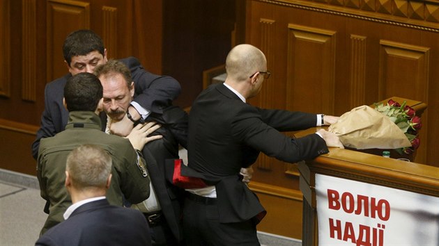 Ukrajinsk zkonodrce Oleh Barna se pokusil v kyjevskm parlamentu odthnout premira Arsenije Jaceuka od enickho pultu (11. prosince 2015)