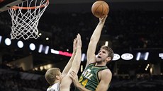 Jeff Withey (24) z Utahu zakonuje pes Matta Bonnera ze San Antonia.