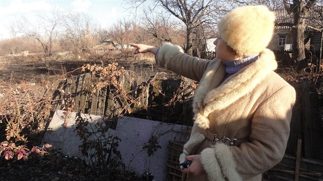 Olga na zahrad svho domku ukazuje, kam ped rokem dopadly rapnely (16. prosince 2015)