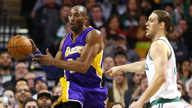 Kobe Bryant (v purpurovm dresu) z LA Lakers pihrv kolem Kellyho Olynyka z Bostonu.