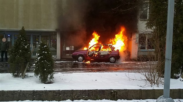 Hoc automobil v sousedstv domu, ktermu plameny pokodily fasdu.