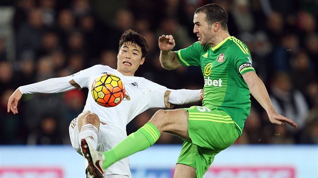 Ki Sung-Yueng (vlevo) v dresu Swansea bojuje o m s kapitnem Sunderlandu Johnem OSheaem.