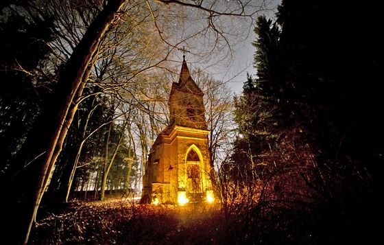 Osvícená plamínky pinesených svíek vypadá kaple u Kvasetic tém romanticky....