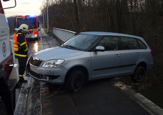 Auto po smyku viselo z mostu.