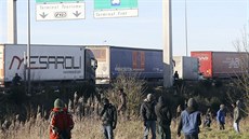 Obyvatelé uprchlického tábora v Calais se snaí dostat do kamion míících do...