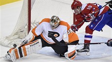 Michal Neuvirth hlídá branku Philadelphie ped dorákou Nicklase Bäckströma z...