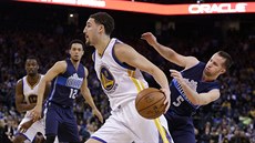 Klay Thompson (v bílém) z Golden State obchází dallaského J. J. Bareu.