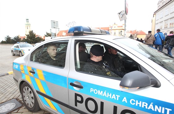 Policisté odváejí 21letého mue (vzadu za spolujezdcem), který vystelil do...