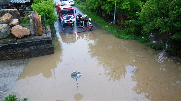 Hasii peerpvaj vodu za protipovodovou zbranou v ulici K Jezu pi povodni v ervnu 2013.